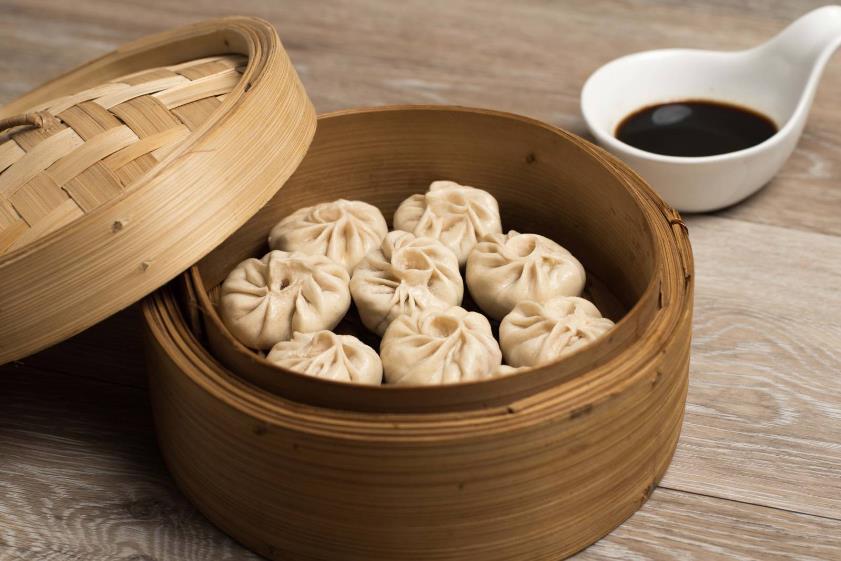 Raviolis chinois servis dans un panier vapeur en bambou chez Jinjiang.